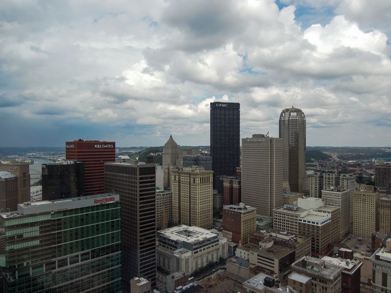 Aerial view of downtown Pittsburgh skyscrapers under a sky of billowing clouds