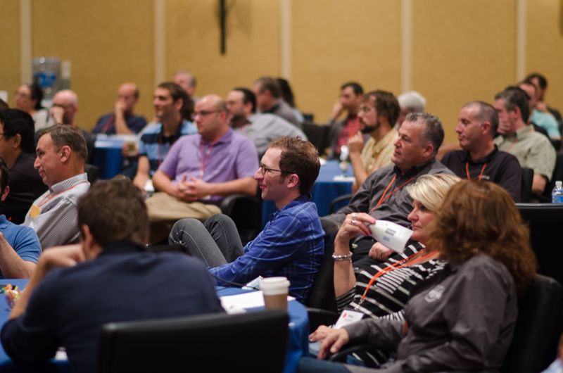 Seated audience members at a conference listening to a talk