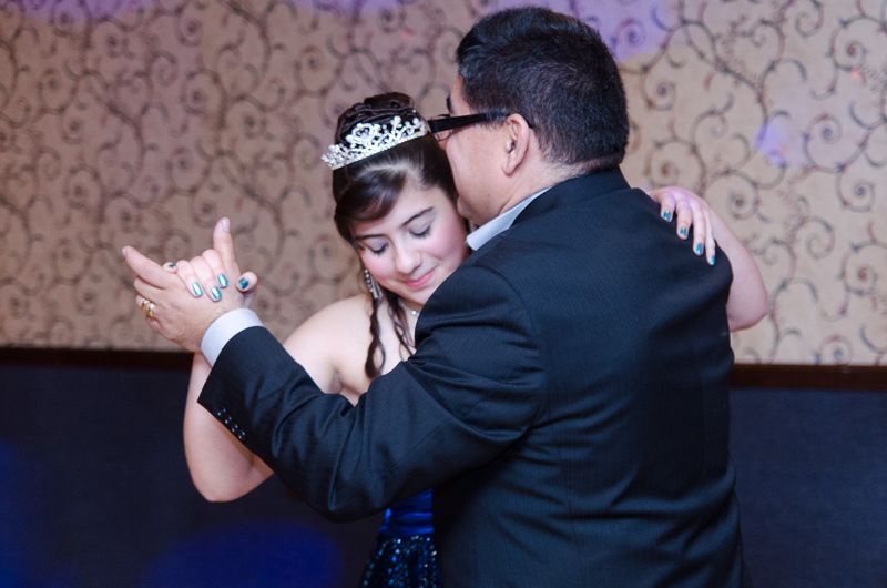 A girl in a tiara sharing a waltz with her father at her quinceañera