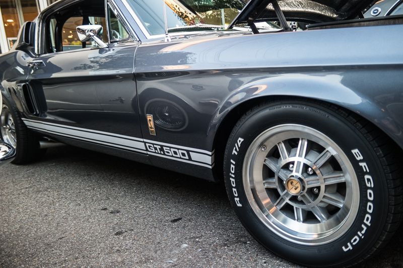 Close-up of the front wheel and white GT500 stripe of a grey Shelby Mustang